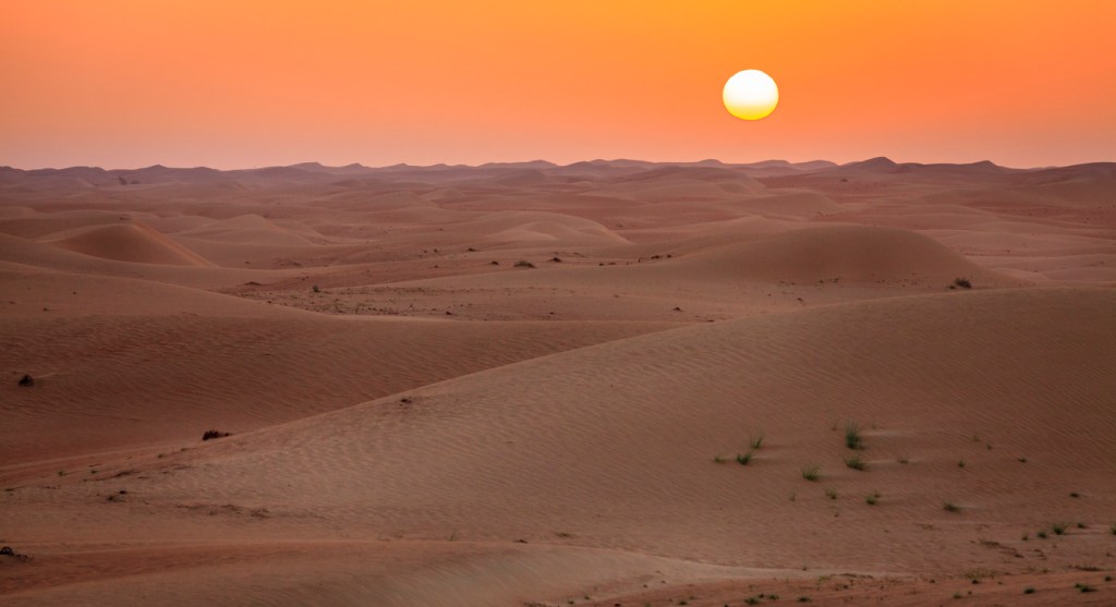 Sun rising over dunes of Dubai Desert Conservation Reserve, UAE