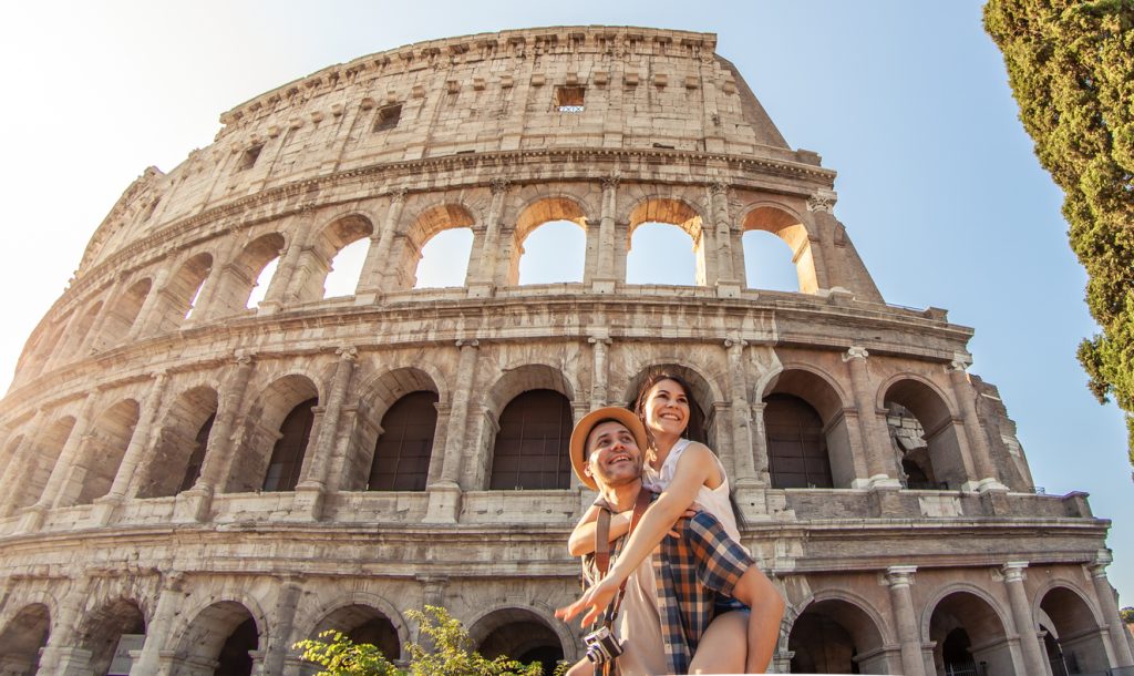 Young happy couple having fun at Colosseum, Rome.